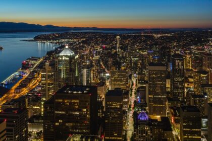 The cityscape of Seattle with tall buildings on one side and a water bay on another