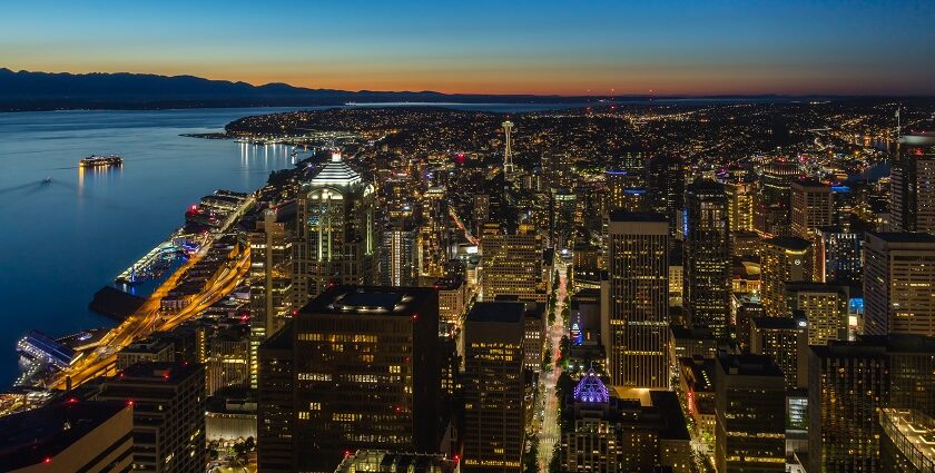 The cityscape of Seattle with tall buildings on one side and a water bay on another