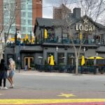 Two women standing on a painted pathway opposite the local pub eatery restaurant