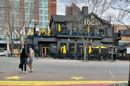 Two women standing on a painted pathway opposite the local pub eatery restaurant