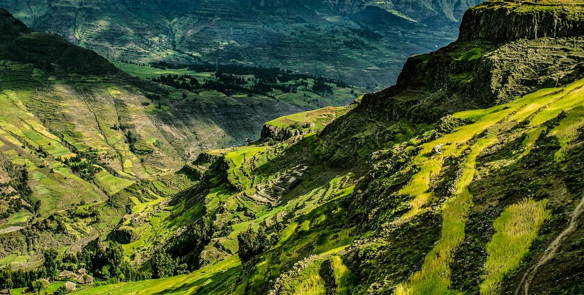 A lush green mountain range and a valley in between is looking divine in soft daylight.