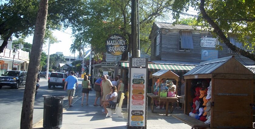 People near a board welcoming tourists in Mallory Square in Florida, USA.