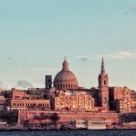 Periodic buildings with typical architecture are standing tall near a vast waterbody.