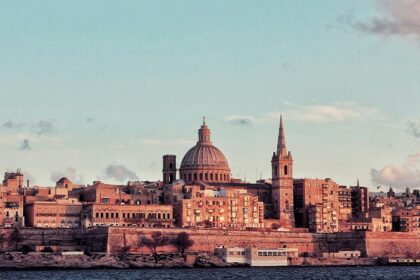 Periodic buildings with typical architecture are standing tall near a vast waterbody.