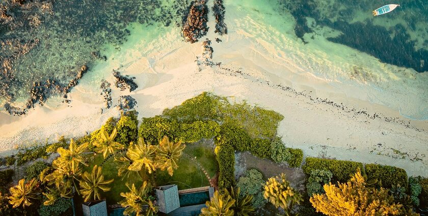 In the middle of the ocean, there is an island with high mountains covered in green.