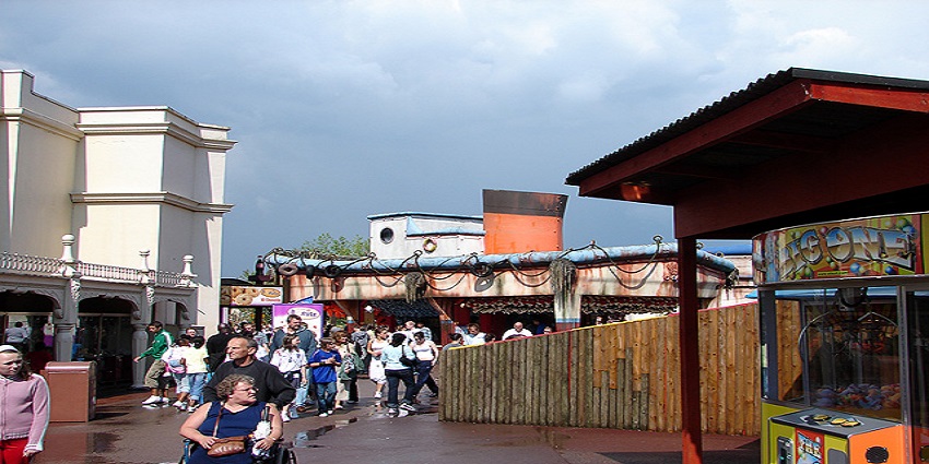 An image of "All the fun of the fair" at Thorpe Park in Surrey, UK, with a crowd enjoying the day.
