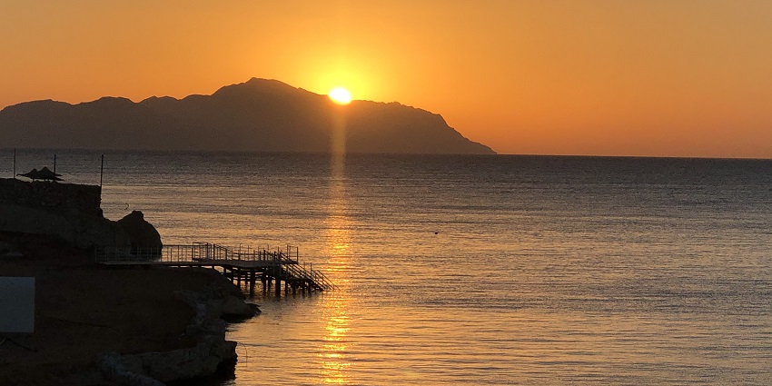 Tiran island in the evening with the sunset, pier and rock in between the ocean