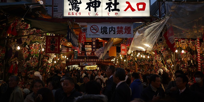 Crowds at Tori-no-Ichi Fair in Asakusa with colorful festival stalls.