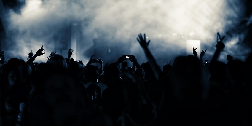 An image of a lead female singer performing on stage at a club concert while enjoying live music.