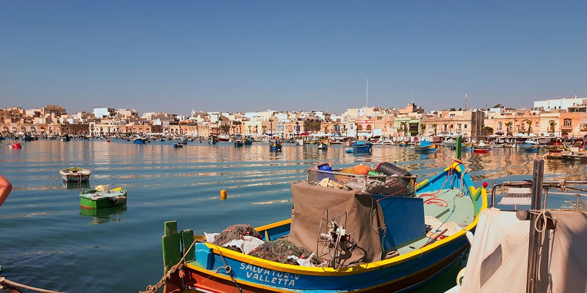Montage of landmarks in Marsaxlokk including the boats, fish market and heritage buildings.