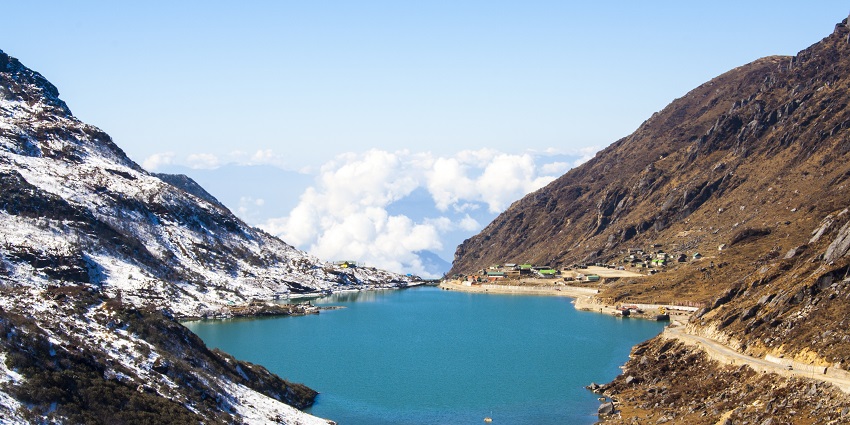 The Sikkim travel guide shows the view of the glacial lake, surrounded by Himalayan landscapes.
