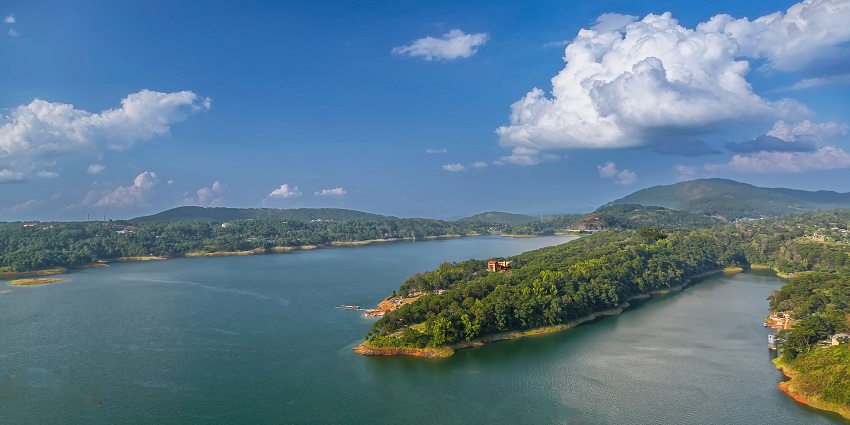 Reservoir surrounded by lush hills and serene landscapes, showcased in Shillong travel guide.