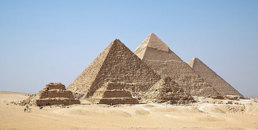 Pyramids of Giza with three tall pyramids and other small ruined pyramids in the desert.