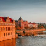 A picture of a boat on a water boat near the high-rise buildings at Charles Bridge.