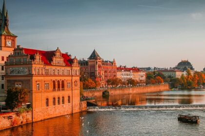 A picture of a boat on a water boat near the high-rise buildings at Charles Bridge.