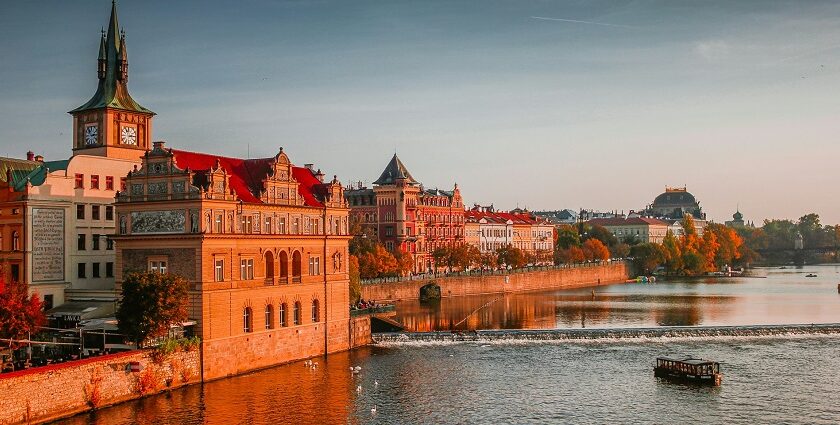 A picture of a boat on a water boat near the high-rise buildings at Charles Bridge.