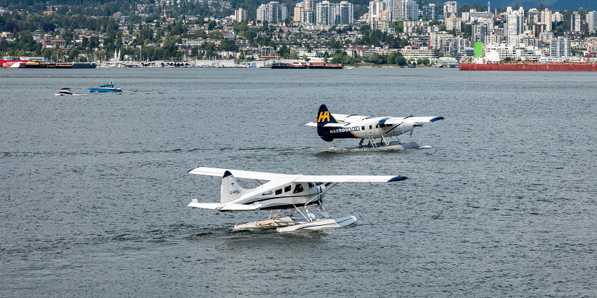 Seaplanes docked at Vancouver Harbour Flight Centre with the city skyline in the background.