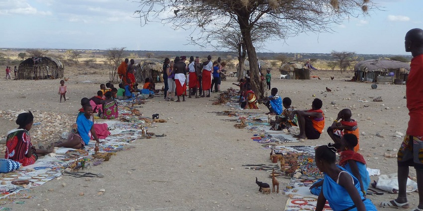 People sitting on the ground selling traditional jewellery in the Samburu village.