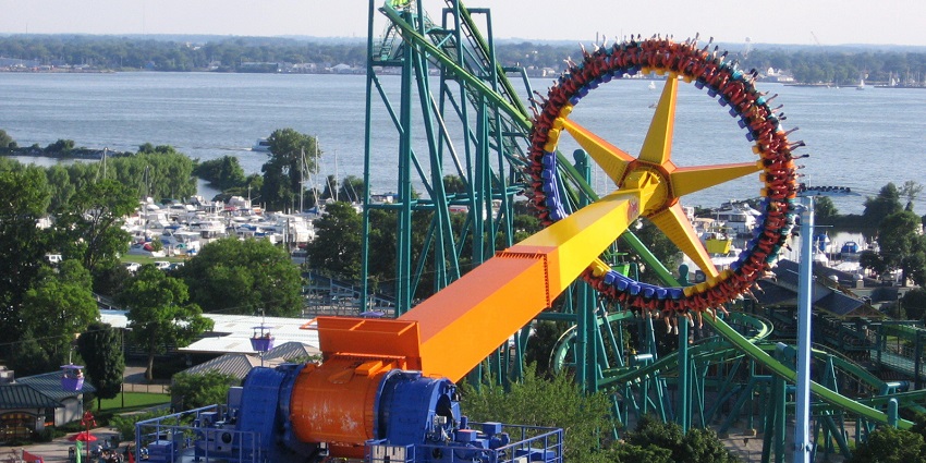 Cedar Point Amusement Park with a red roller coaster track and people seated on the ride
