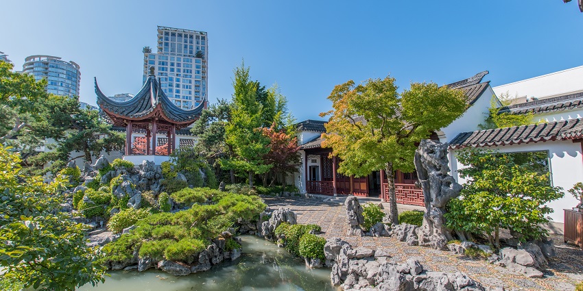 Image of Classical Chinese Garden with Chinese style architecture and tall building.