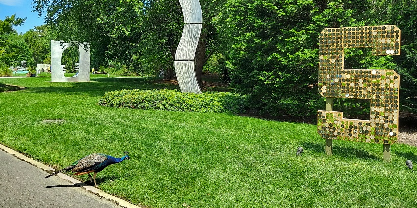 Grounds for sculpture with unique models surrounded by greenery and a small peacock