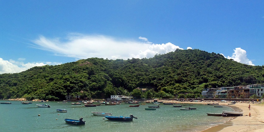 Image of Pen Chau near the seashore and a lush green hill covered during day time