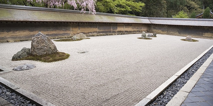Zen rock garden symbolizing simplicity and tranquility amidst temple grounds