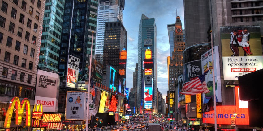 Times Square in the daytime, surrounded by the big LED screens and advertisements.