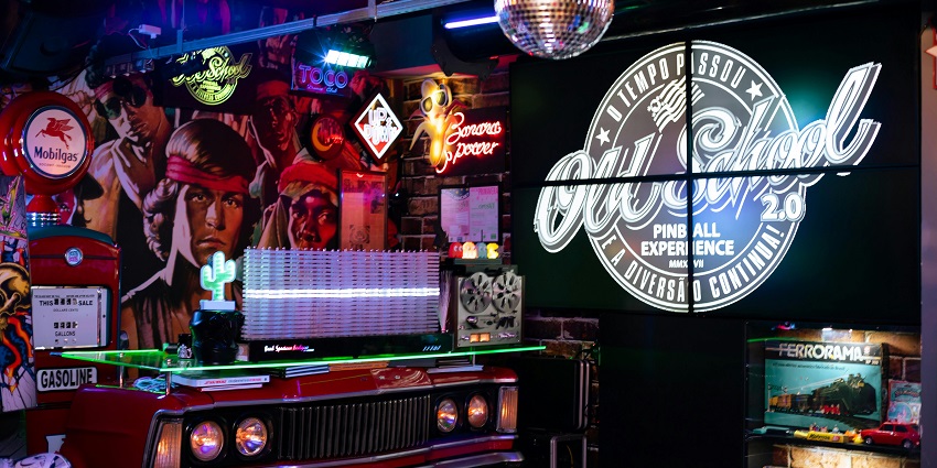 Inside a vibrant old school bar with painted walls, a disco ball and a car-shaped counter.