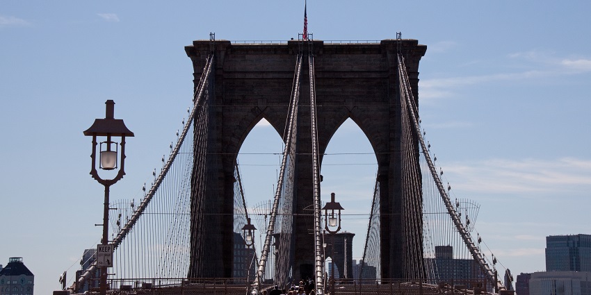 An image of people walking across the Brooklyn Bridge, one among the best things to do in NYC for valentines day.