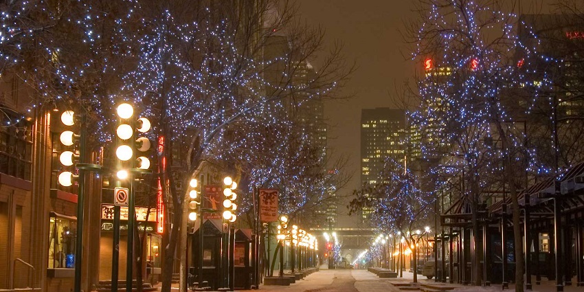 Stephen Avenue at night with the street covered in snow and lights on the dried trees