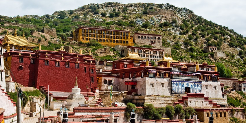 Walk along the Kora path in the Ganden monastery.