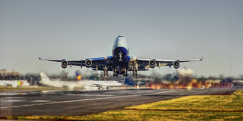 A view of an Airplane taking off from the runway with clear skies in the background