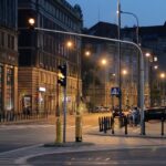 Roads of Warsaw at night with street lamps, people walking in the lanes near the shops.