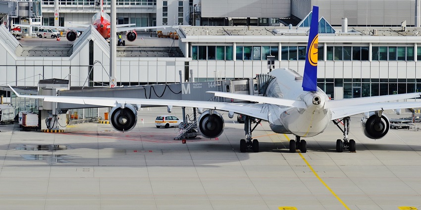 A view of an aeroplane in the sky above an airport, ready for passenger boarding.