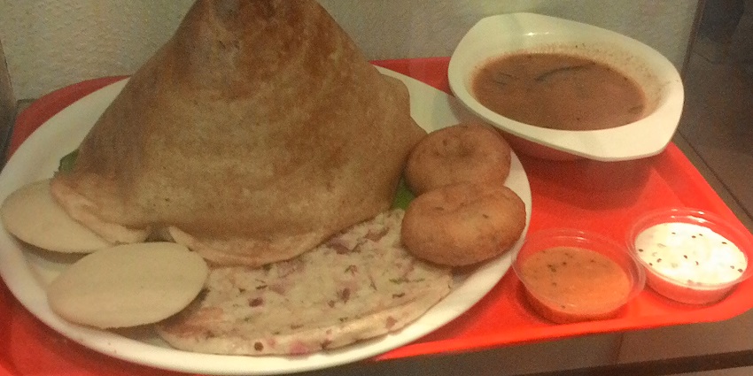 Dosa, idli on a plate, sambar in a bowl with coconut chutney, to enjoy while visiting Kanjanur Temple.