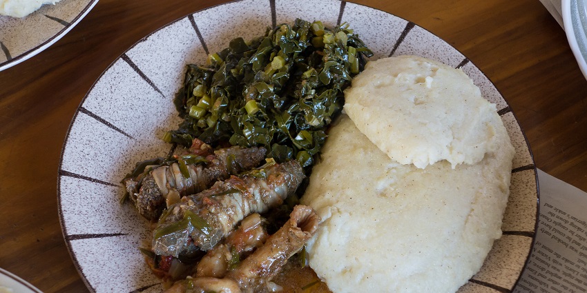 Typical Zimbabwean meal, with sadza, greens and goat offal.