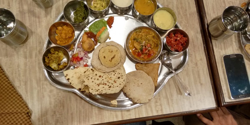 Image of Ujjain’s delightful thali with a variety of dishes served on a steel plate