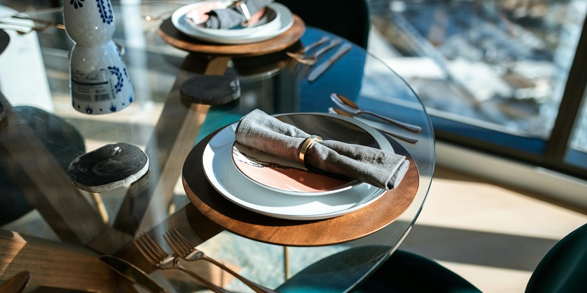 An image showing black thread arranged on a brown round plate in a restaurant.
