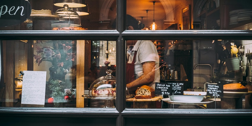 Image of a woman working in a cafe cum restaurent with delectable food serving service