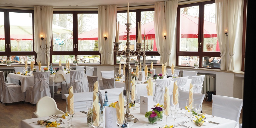 An image showing a sophisticated restaurant dining area with tables beautifully arranged for guests.