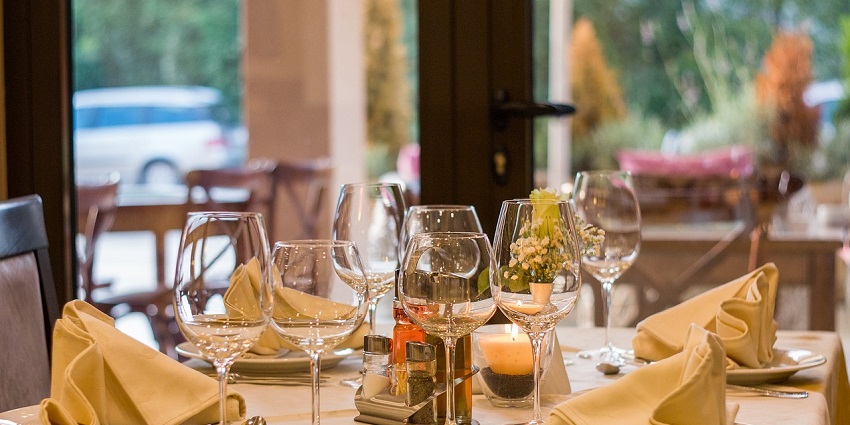 Elegant restaurant table setting with plates, cutlery, and glassware arranged neatly.