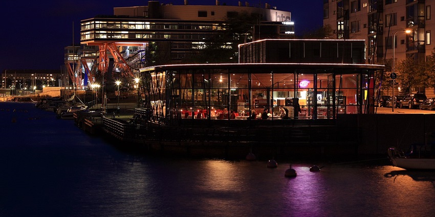 Night view of a restaurant in Finland filled with customers enjoying their food.