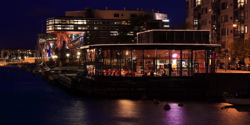 Night view of a restaurant in Finland filled with customers enjoying their food.
