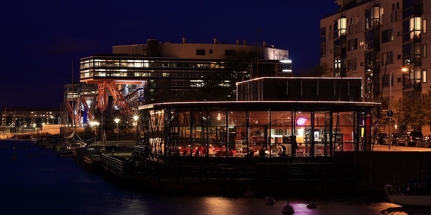 Night view of a restaurant in Finland filled with customers enjoying their food.