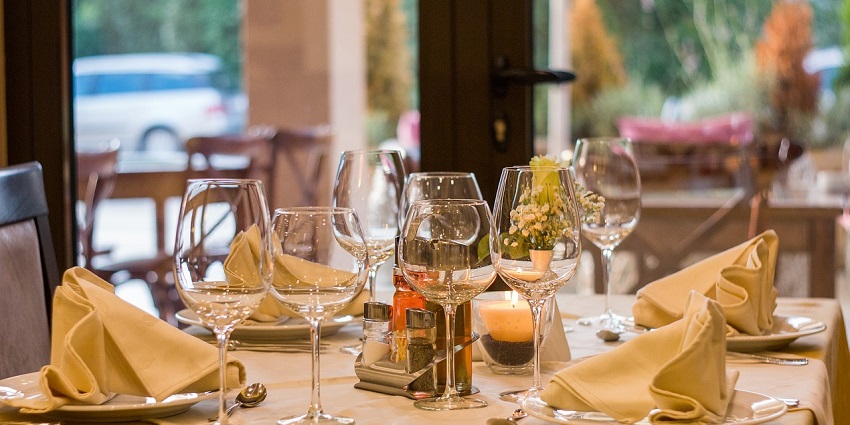 A fine dining setting with wine glasses and beige table cloth showing the availability of a comfortable dining space for visitors.