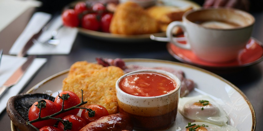 An image of a table filled with a variety of fresh salads, bread, and appetizers