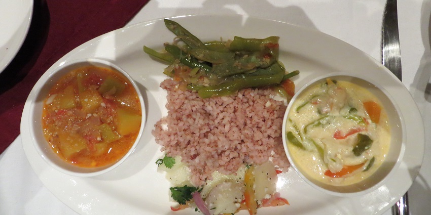 Image of a traditional food thali served on a white plate on a table
