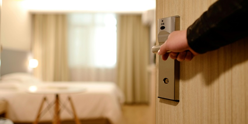A person opening the door of a room in budget-friendly hotel in Raipur, Chhattisgarh