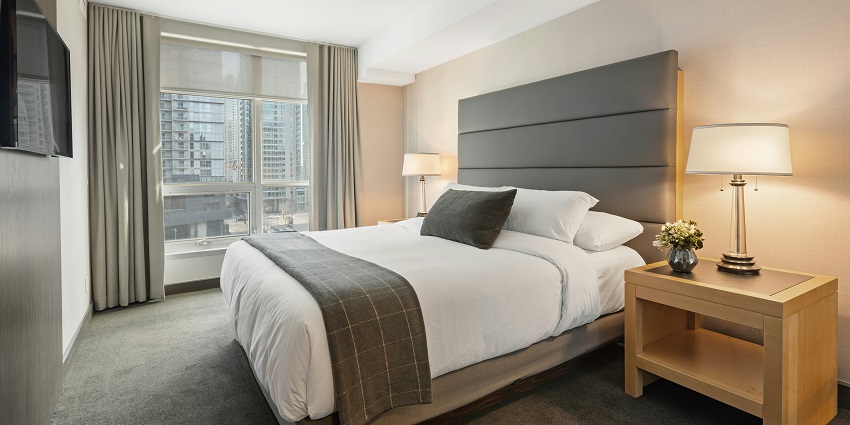 A lavish executive suite room with a view of a river from a glass window